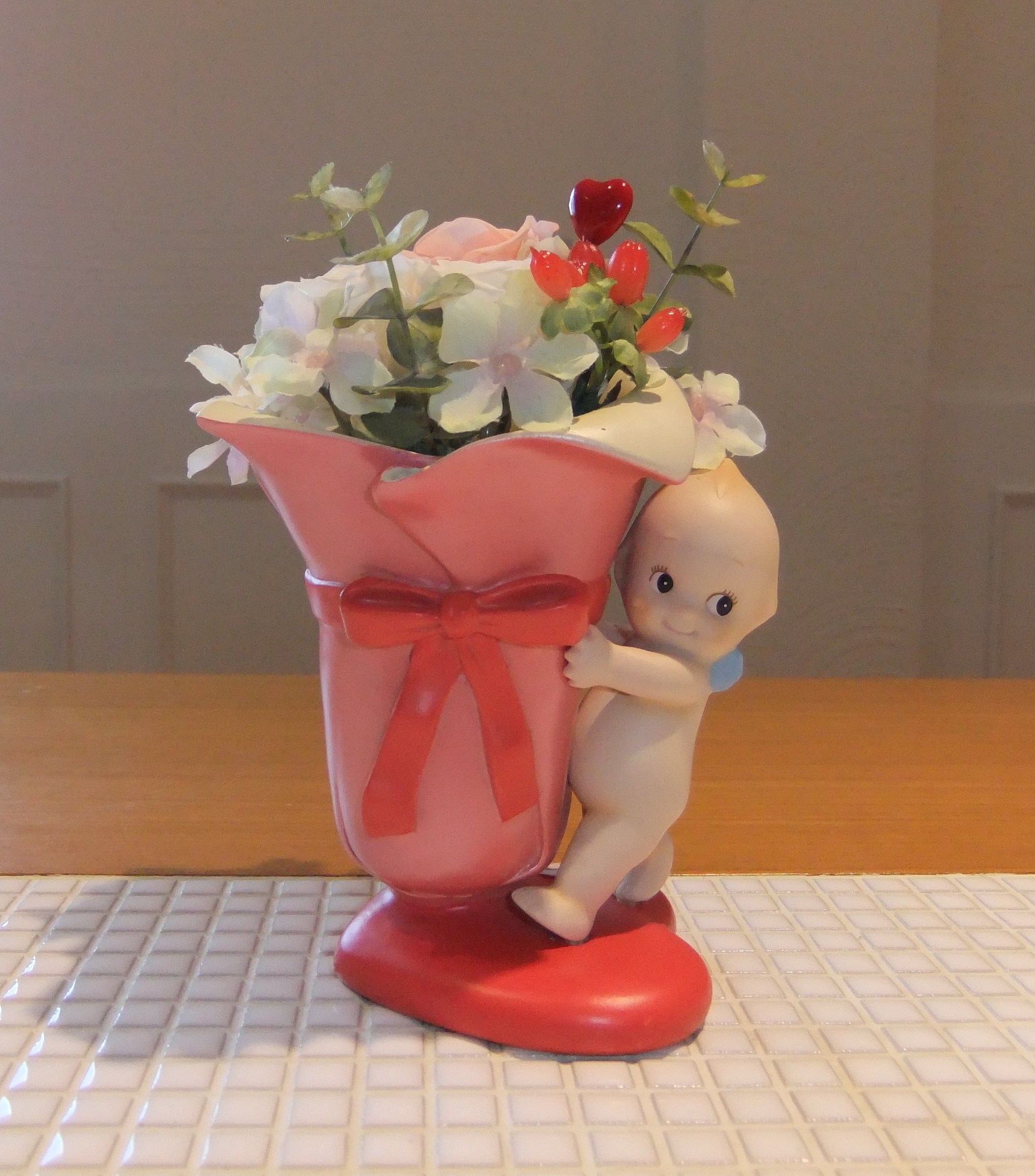 キュートなキューピーの花器にプリザーブドフラワーのアレンジ。誕生日や出産のお祝いに、笑顔を運んでくれます♪